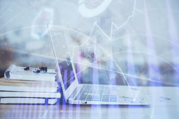 Forex graph hologram on table with computer background. Multi exposure. Concept of financial markets.