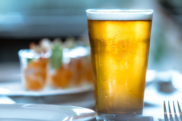 Glass of beer on the table in a food time