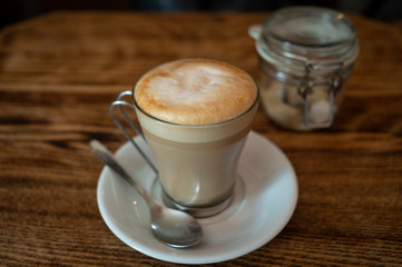 Latte coffee in a glass cup on a cafe table