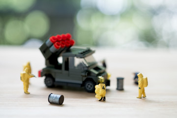 Miniature chemical team in hazmat suits examining integrated