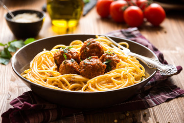 Delicious spaghetti with meatballs in tomato sauce on dark background, italian cuisine