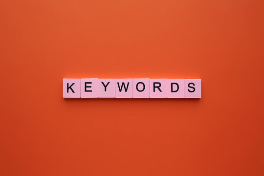 Keywords word wooden cubes on an orange background.