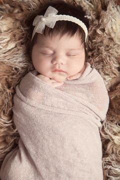 Newborn baby girl sleeping soundly, wrapped