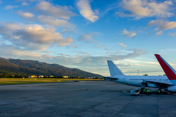 Fototapeta na wymiar Airport with many airplanes at beautiful sky and mountain.