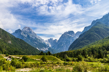 Fototapeta na wymiar Panoramic view on Mangart-Jalovec Mountain Massive in the Julian Alps inside beautiful Landscape. Log pod Mangartom, Bovec, Slovenia, Europe.