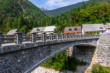 Fototapeta na wymiar Bridge over River Predelica from Predil Pass in Village Log pod Mangartom. Bovec, Slovenia, Europe.