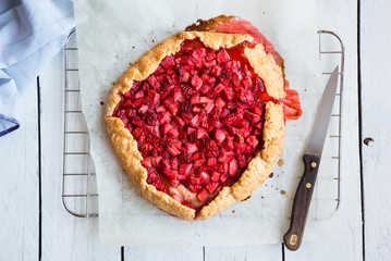 Homemade sweet strawberry cake with fresh strawberries on white wooden table