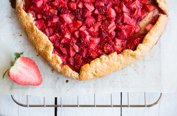 Homemade sweet strawberry cake with fresh strawberries on white wooden table