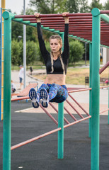 athletic girl doing exercises on the abs on the playground