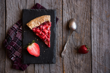 Homemade sweet strawberry cake with fresh strawberries on dark background