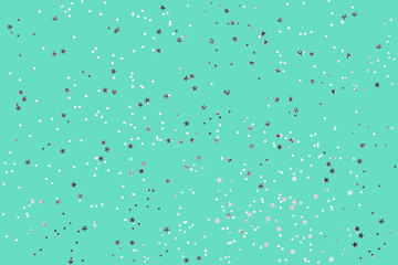 Green mint background with silver glitter and metallic stars. Flat lay style