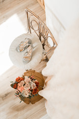 Smiling brunette bride in a white coat and lingerie. The morning of the bride. Wedding portrait of...