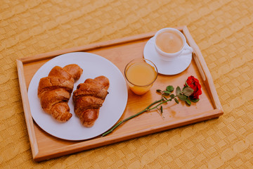 Breakfast in bed, orange juice and croissants with a cup of coffee