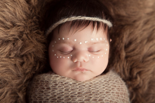 Newborn baby aboriginal girl, traditional facepaint.