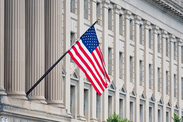 American flag on the facade of a historic building - image