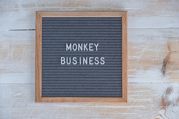 grey felt Board with English text monkey business. English idiom about business