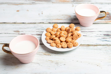 Aerial view of a plate with cookies and two cups with milk