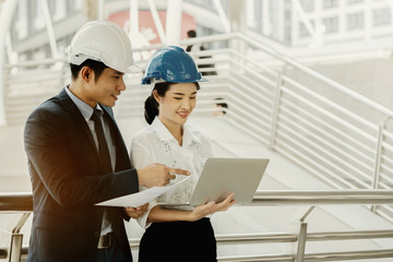 Asian engineer chief consult with secretary. Quality engineers or construction teamwork. Safety concern for engineering or building work site or plant. Wearing helmet and protective equipment can safe