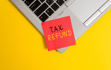Writing note showing Tax Refund. Business concept for refund on tax when the tax liability is less than the tax paid Metallic trendy laptop blank sticky note empty text colored background