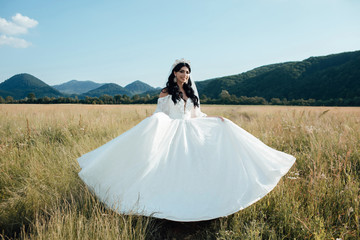 The beautiful woman. Beautiful bride in fashion wedding dress on natural background.The stunning...