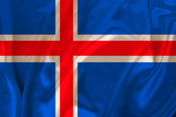 Fototapeta premium photo of iceland state national flag on luxurious texture of satin, silk with waves, folds and highlights, closeup, copy space, illustration