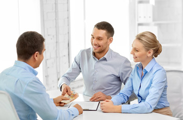 Obraz premium finance, corporate and people concept - business people with contract and money at office