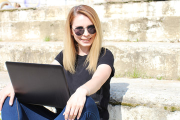Beauty using a modern netbook writes an article outside the workplace. Free work schedule for an IT specialist.
