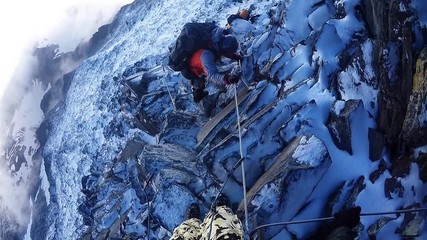 Team climbers coming down from the mountain in snow rock
