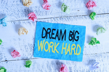 Word writing text Dream Big Work Hard. Business photo showcasing Believe in yourself and follow the dreams and goals Crumpled colored rectangle square shaped paper reminder white wood desk