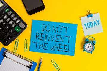Writing note showing Do Not Reinvent The Wheel. Business concept for stop duplicating a basic method previously done Clipboard sheet calculator pencil clock smartphone color background