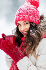 people, season and christmas concept - happy teenage girl or young woman with tea cup outdoors in winter