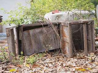 Old broken wooden table abandoned outdoor with natural green background in rural countryside.