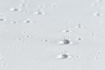 Water drops on beige waterproof fabric. Technologies of water-repellent materials.