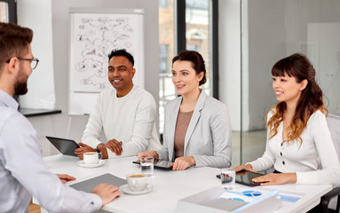 new job, hiring and employment concept - international team of recruiters with tablet pc computers having interview with male employee at office