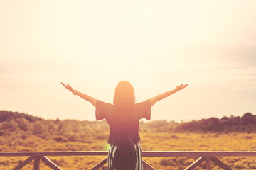 Copy space of woman rise hand up on top of mountain and sunset sky abstract background.