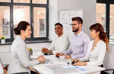 new job, hiring and employment concept - international team of recruiters having interview with female employee at office