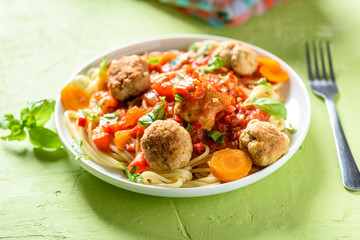 homemade pasta with tomato sauce and cooked meatballs