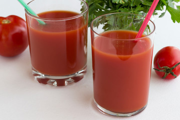 Tomato juice, tomatoes and a bunch of green parsley on a white background