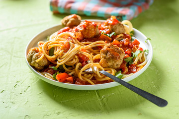 homemade pasta with tomato sauce and cooked meatballs