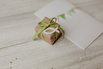 Religion, Glaube - Geschenk mit recyclingpapier, grüner Schleife und weißem Fisch