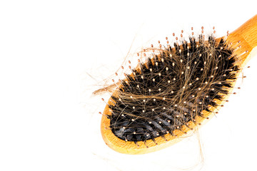 Wood hairbrush on white background. Close-up with long brown hair