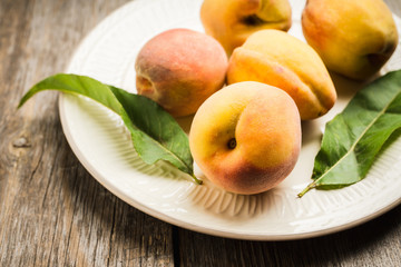 Sweet ripe peaches on the rustic background. Selective focus. Shallow depth of field.