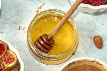 Honey and honey spoon in a jar on the table