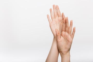 Woman's hands isolated over white wall background touching each other.