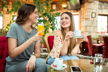 Two best friends drinking coffee and orange juice
