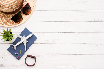 Flat lay planing and traveler concept on white wooden table background with passport and plane, hat and sunglasses, Top view with copy space