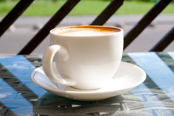 Cappuccino in white cup on table at cafe. Copyspace. Bewerages, coffee lovers and morning menu concept. Stylish nature and stripped background