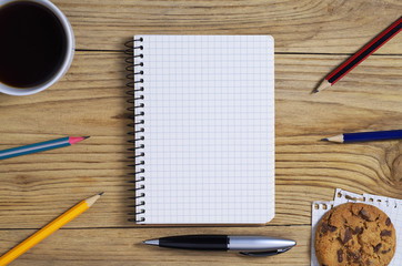 Notepad and coffee with cookies