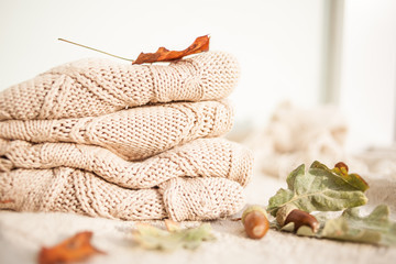 Knitted wool sweaters. Pile of knitted winter, autumn clothes knitwear.