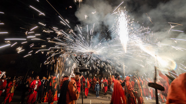 People dressed as devils lighting pyrotechnics